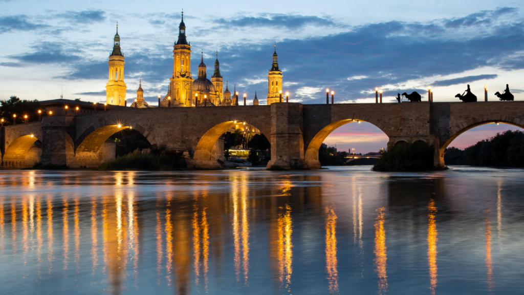 Los reyes magos llegan a Zaragoza por el puente de piedra. Vista de fondo de la basílica del Pilar